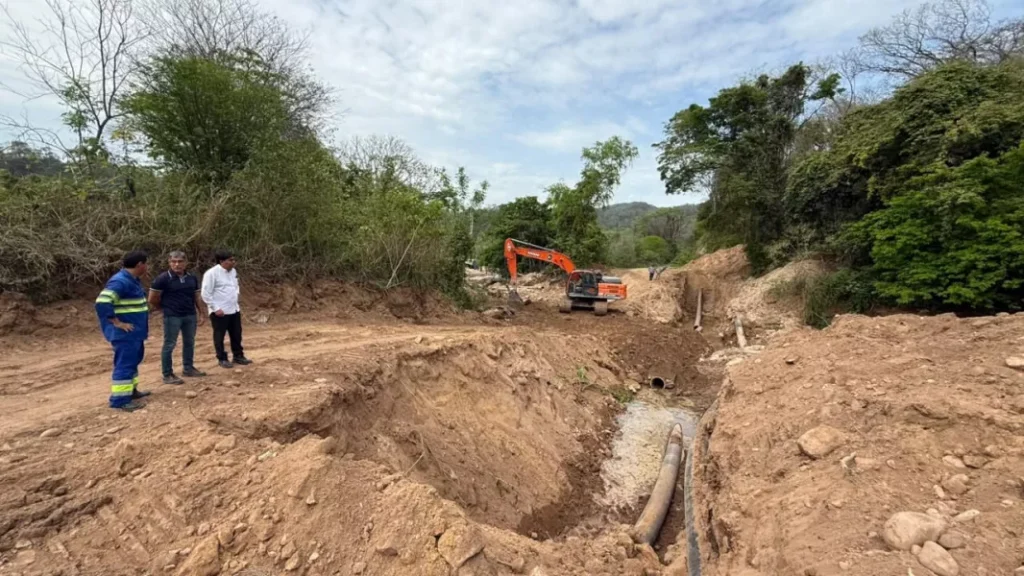 Maquinaria y operarios trabajan en una excavación junto a cañerías del sistema de abastecimiento de agua potable.